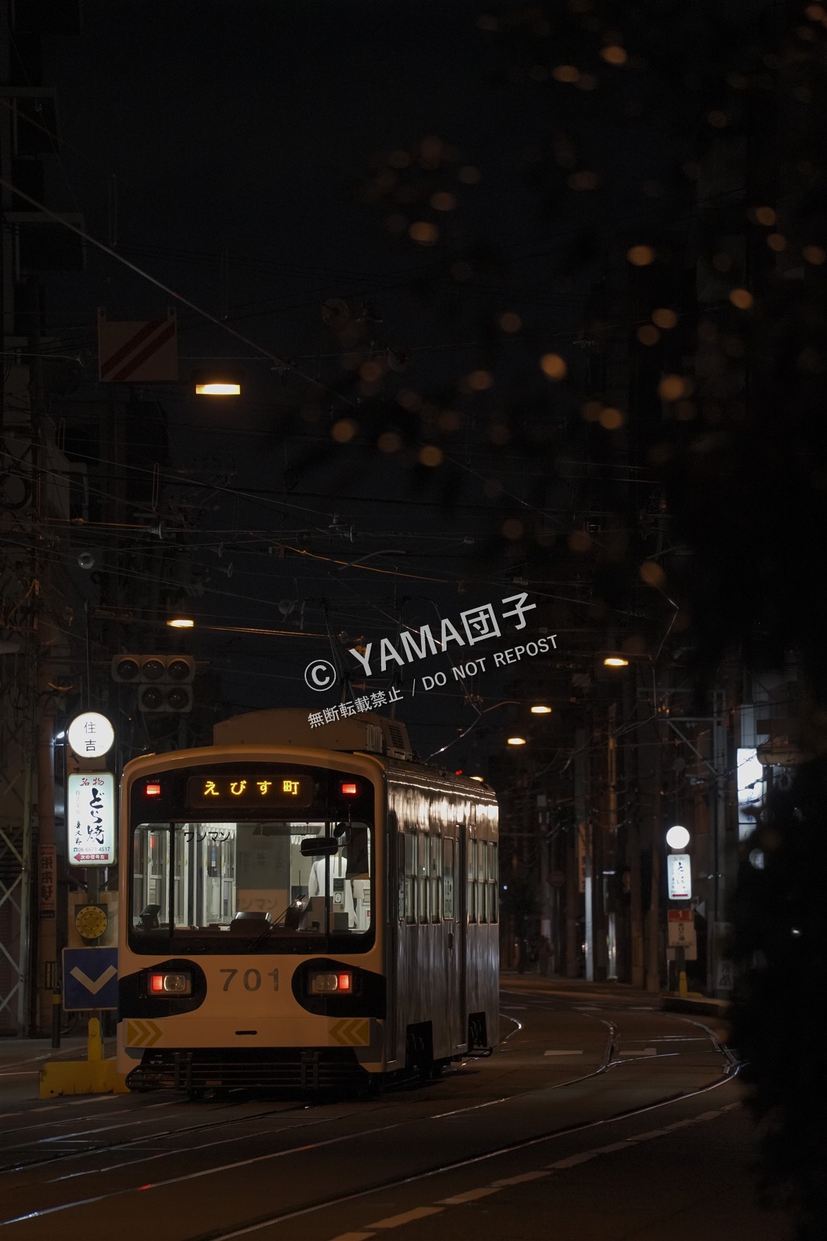 街灯がともる夜の街を走る路面電車